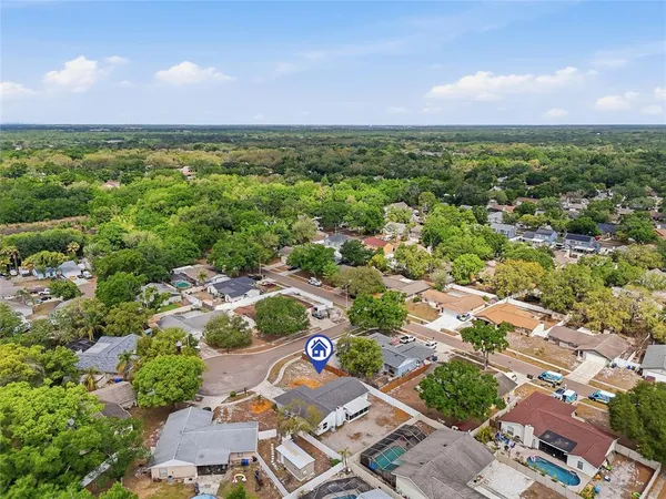 an aerial view of residential houses with outdoor space and trees