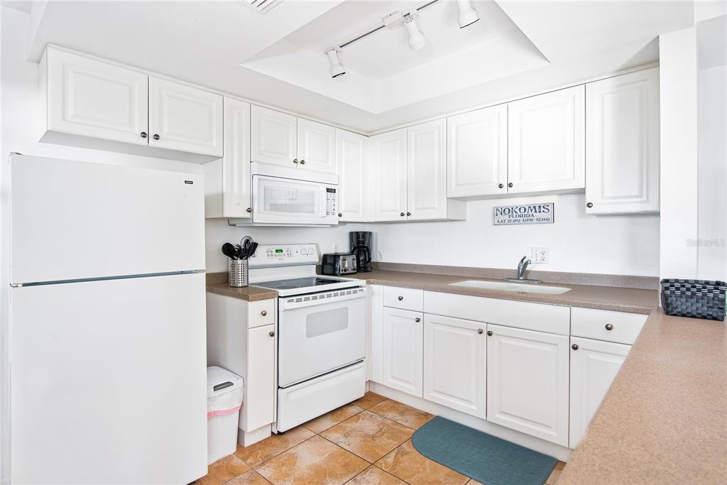 217 Casey Key Road Nokomis, FL 34275 - Photo 40 of 51 a kitchen with granite countertop white cabinets and white appliances