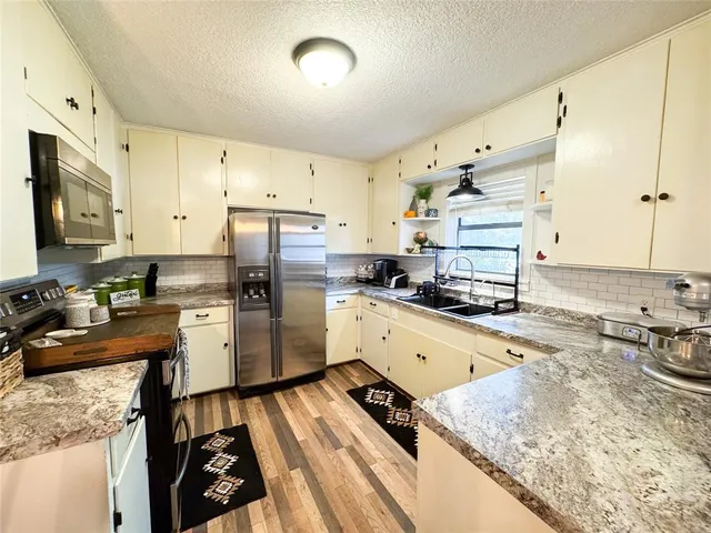 a kitchen with a stove a sink dishwasher and a refrigerator