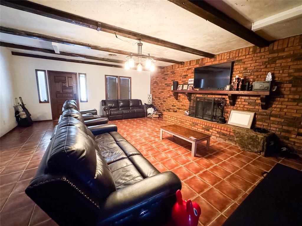 1303 Grand Central Avenue O'Brien, TX 79539 - Photo 18 of 40 a living room with furniture a flat screen tv and a table