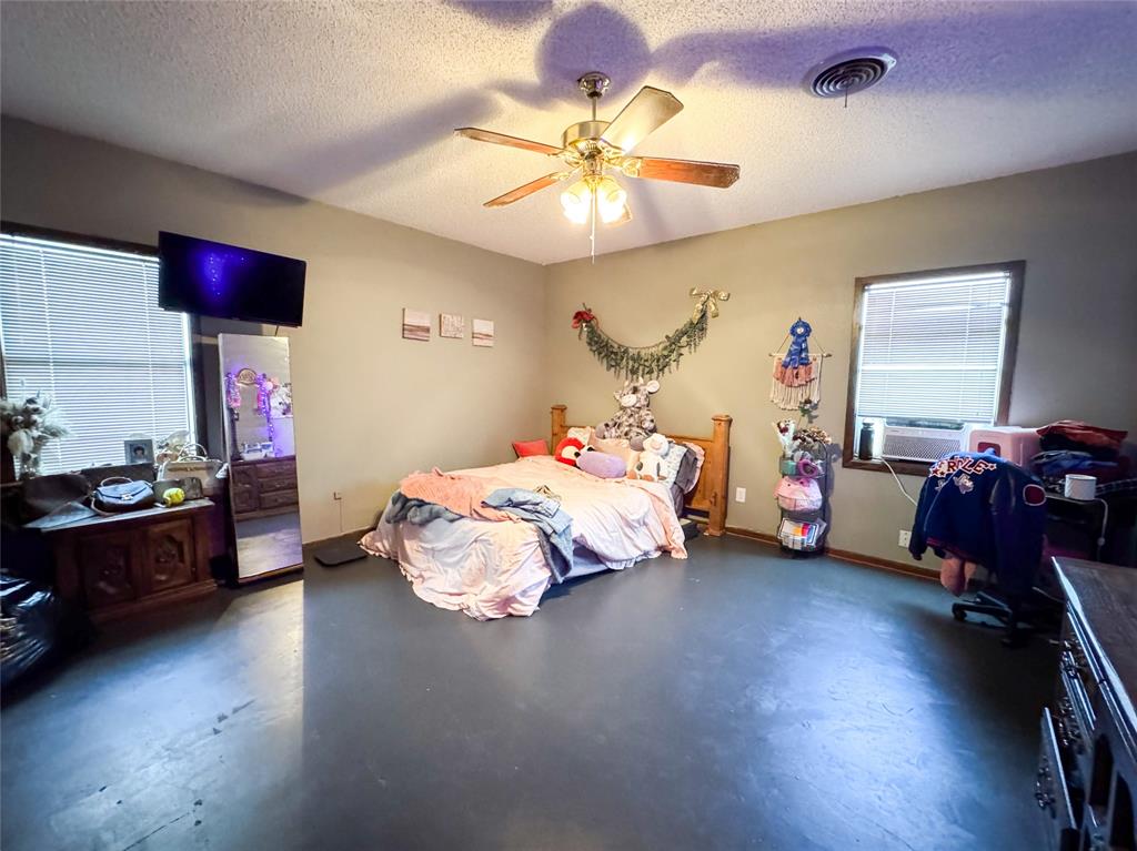 1303 Grand Central Avenue O'Brien, TX 79539 - Photo 19 of 40 a bedroom with a bed and ceiling fan