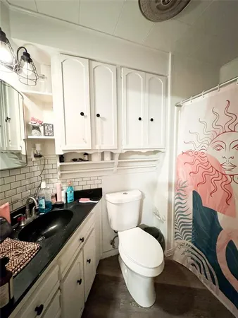 a bathroom with a granite countertop toilet sink and mirror