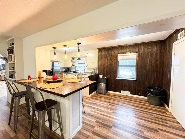 a room with a table chairs and a kitchen view
