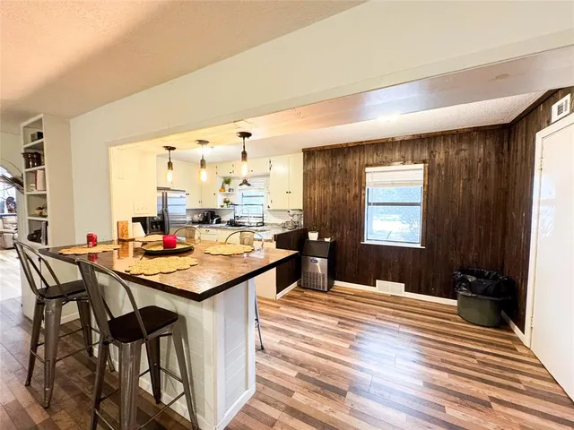 a room with a table chairs and a kitchen view