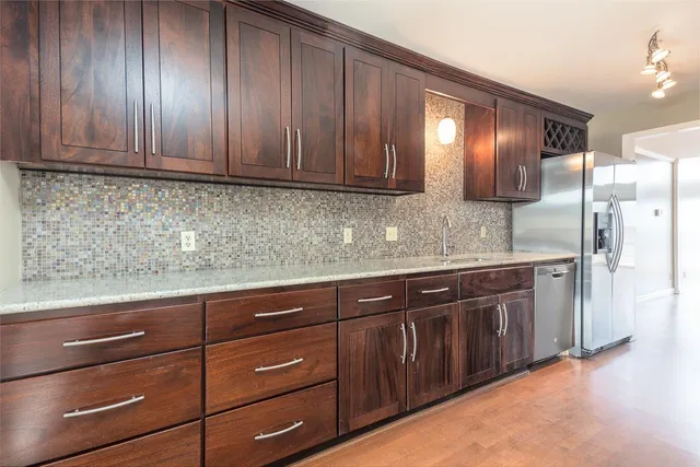 a kitchen with stainless steel appliances granite countertop a sink a stove and a microwave