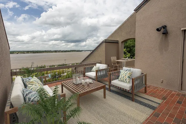 a roof deck with couches and wooden floor
