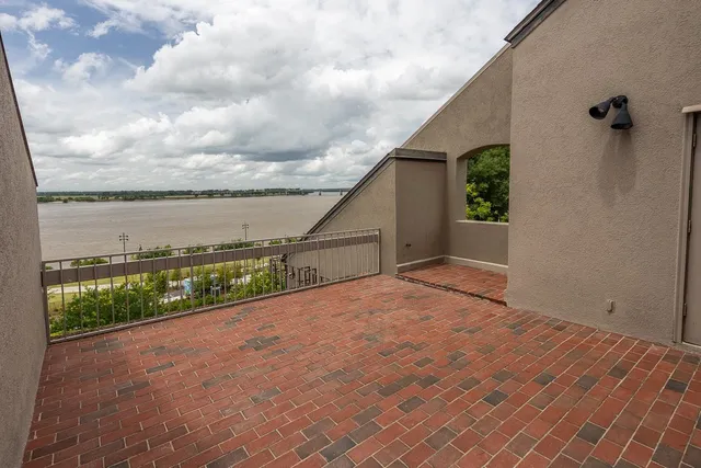 a view of an empty room with wooden floor fireplace and a window