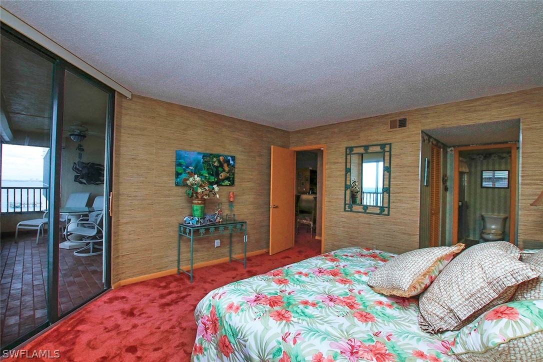 15021 Punta Rassa Road, Unit 602 Fort Myers, FL 33908 - Photo 12 of 35 a bedroom with a bed and dresser with mirror