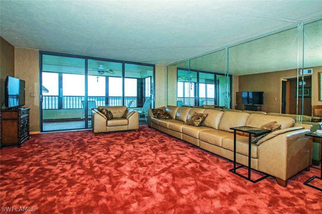 15021 Punta Rassa Road, Unit 602 Fort Myers, FL 33908 - Photo 2 of 35 a living room with a couch and a flat screen tv