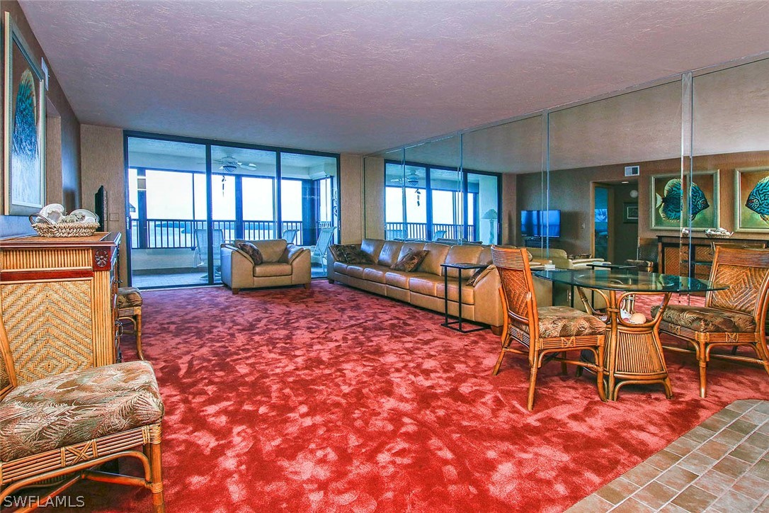 15021 Punta Rassa Road, Unit 602 Fort Myers, FL 33908 - Photo 5 of 35 a living room with furniture a fireplace and large windows