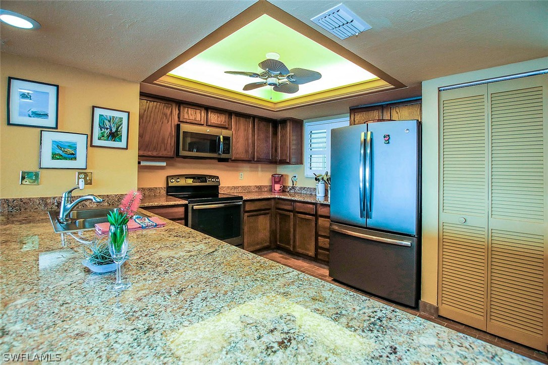 15021 Punta Rassa Road, Unit 602 Fort Myers, FL 33908 - Photo 6 of 35 a kitchen with stainless steel appliances granite countertop a refrigerator and a stove top oven