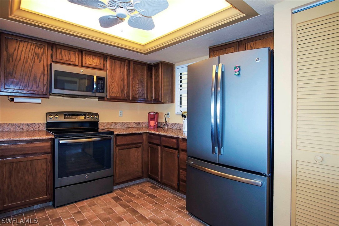 15021 Punta Rassa Road, Unit 602 Fort Myers, FL 33908 - Photo 8 of 35 a kitchen with stainless steel appliances granite countertop wooden cabinets a stove top oven a sink and dishwasher