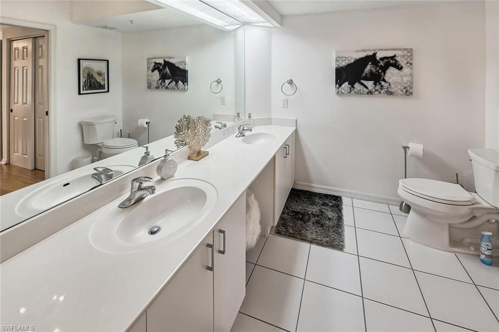 6910 Satinleaf Road North, Unit 101 Naples, FL 34109 - Photo 13 of 30 Bathroom with tile patterned flooring, vanity, and toilet