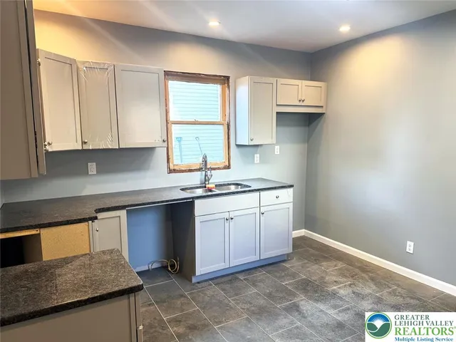a kitchen with a sink cabinets and window