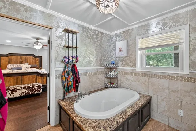 a bathroom with a granite countertop sink a mirror and shower