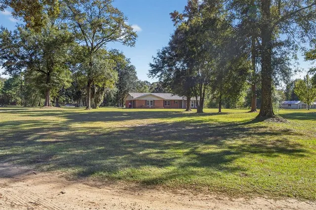 a front view of a house with a yard and trees