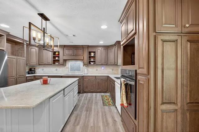 a kitchen with stainless steel appliances granite countertop a sink refrigerator and cabinets