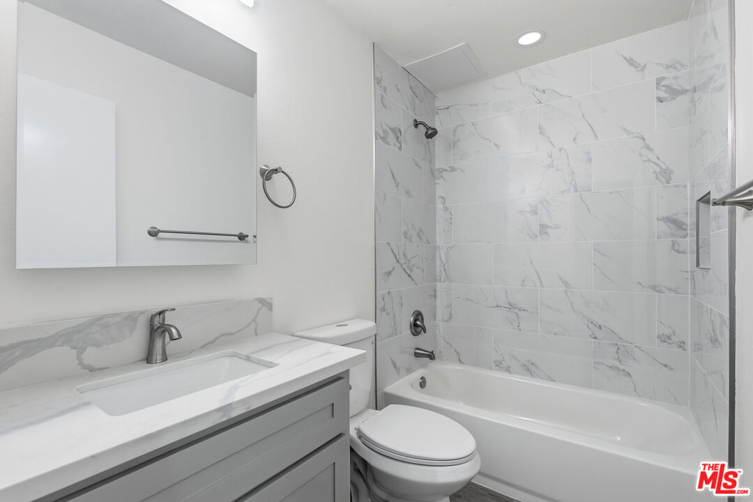 4836 Hollow Corner Road, Unit 312 Culver City, CA 90230 - Photo 13 of 29 a bathroom with a granite countertop sink a toilet and a bathtub
