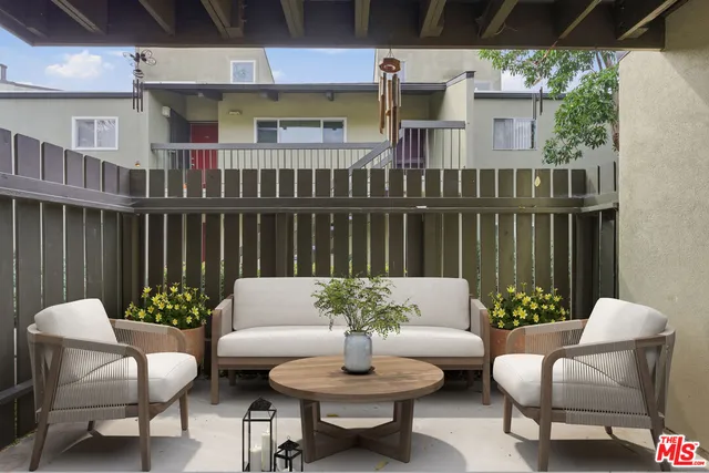 a view of a patio with couches table and chairs and potted plants