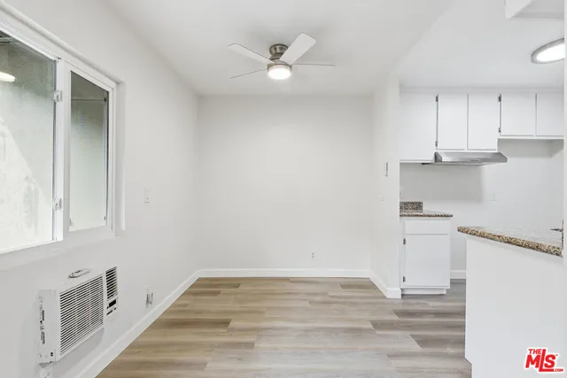 an empty room with wooden floor and window