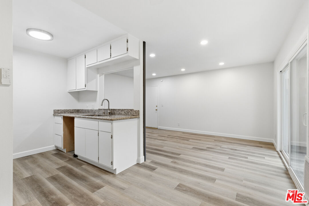 4836 Hollow Corner Road, Unit 312 Culver City, CA 90230 - Photo 5 of 29 a room with granite countertop white cabinets and a sink