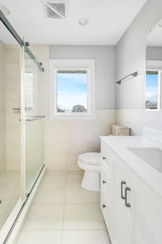 a bathroom with a sink a toilet and shower