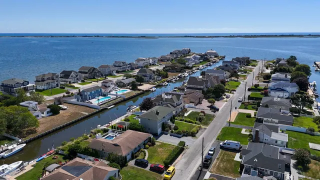 an aerial view of ocean and residential houses with outdoor space
