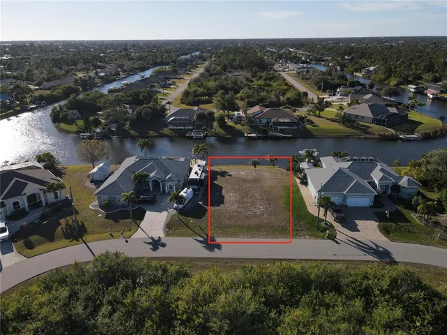 an aerial view of a house with a yard and lake view