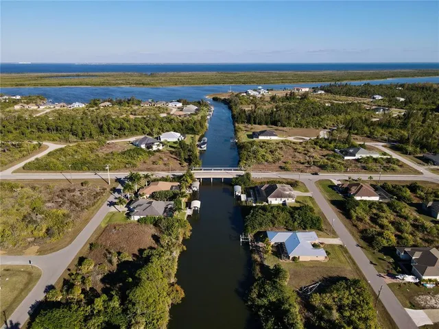 an aerial view of ocean and residential houses with outdoor space