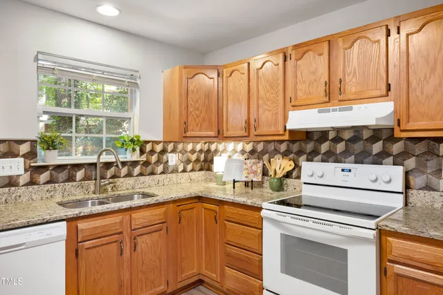 a kitchen with stainless steel appliances a sink a stove and cabinets