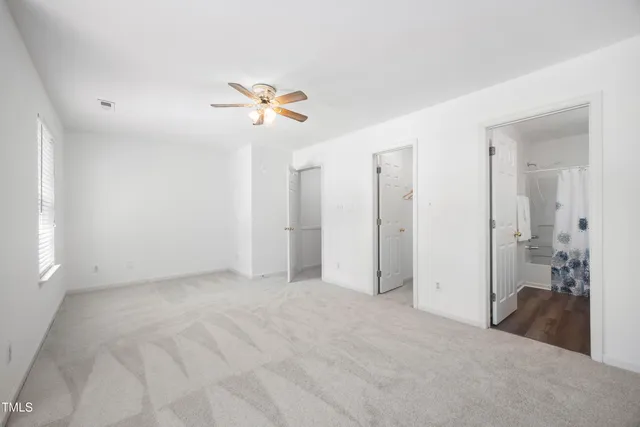 a view of a room with a ceiling fan and shower