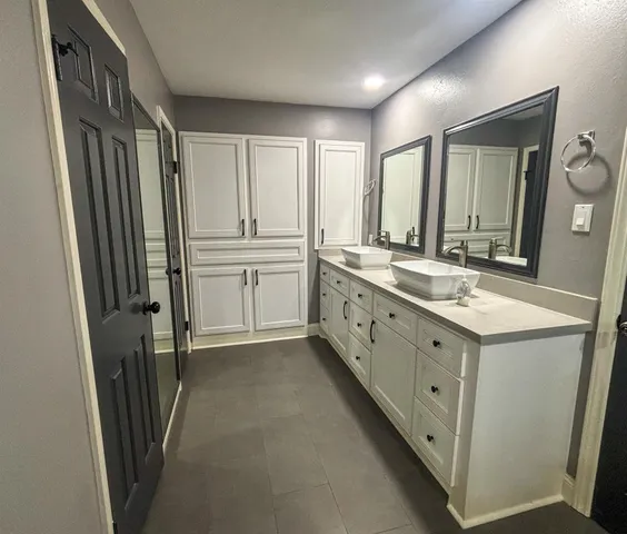 a bathroom with double vanity sink and mirror
