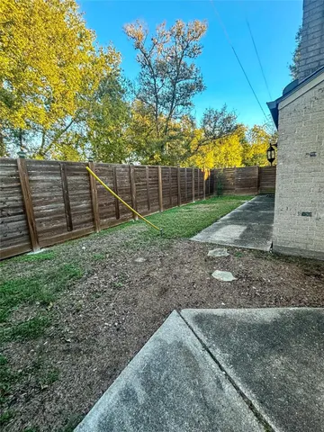 a view of backyard with wooden fence