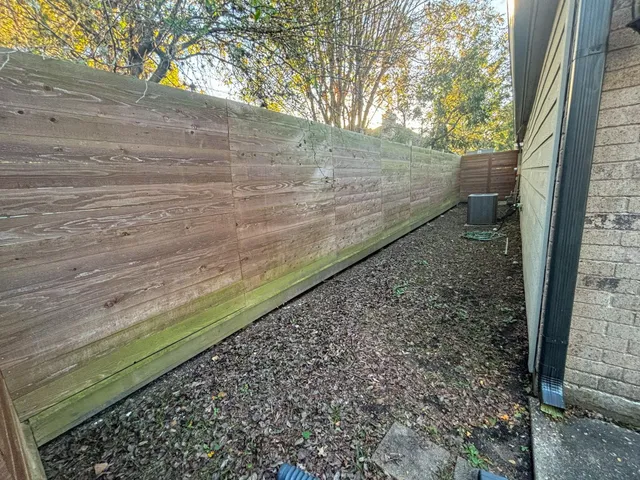 a view of a yard with wooden fence