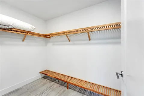 a view of a hallway with wooden floor and windows