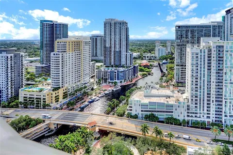 a living room with furniture a potted plant and kitchen view