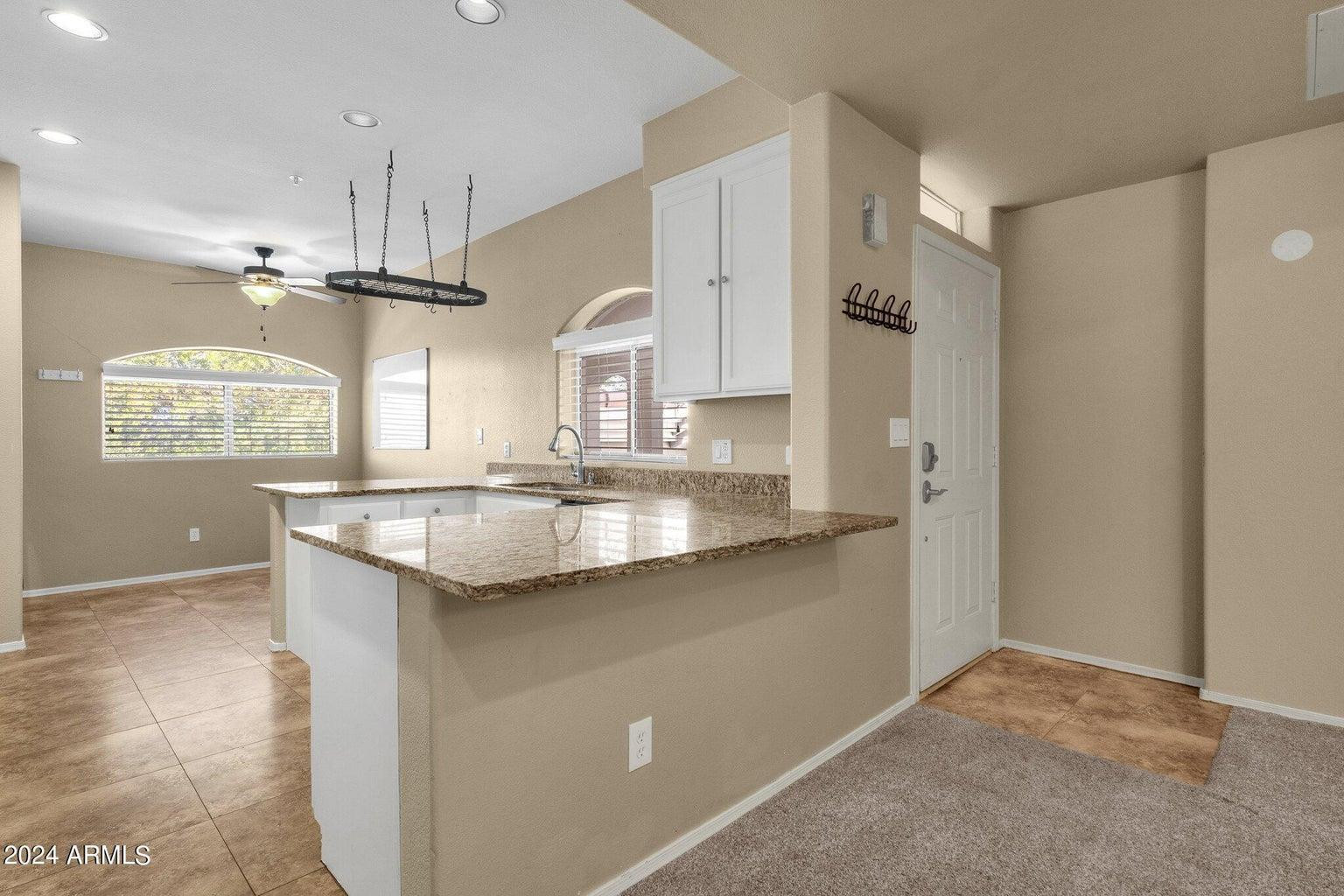 8653 East Royal Palm Road, Unit 2014 Scottsdale, AZ 85258 - Photo 4 of 4 a kitchen with granite countertop a sink a counter space appliances and cabinets