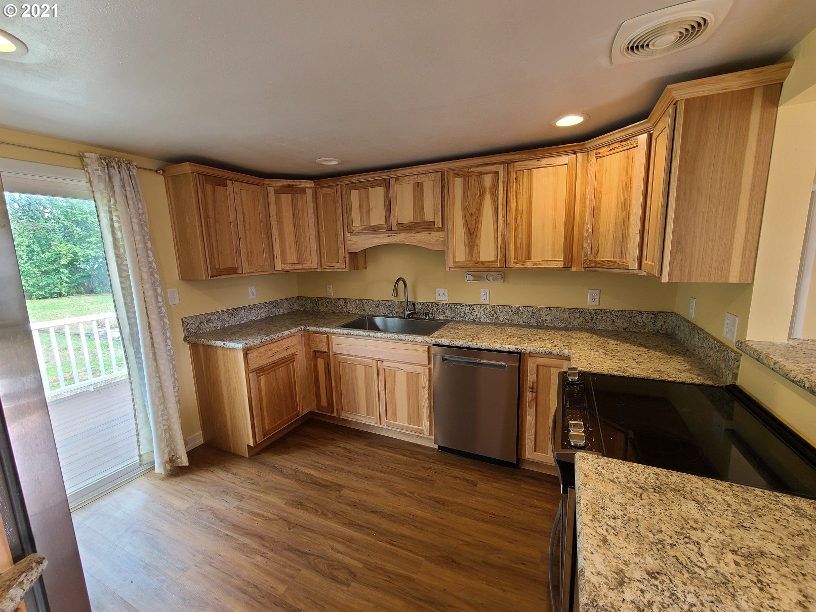 5158 D Street Springfield, OR 97478 - Photo 3 of 14 a kitchen with granite countertop white cabinets a sink and dishwasher with wooden floor
