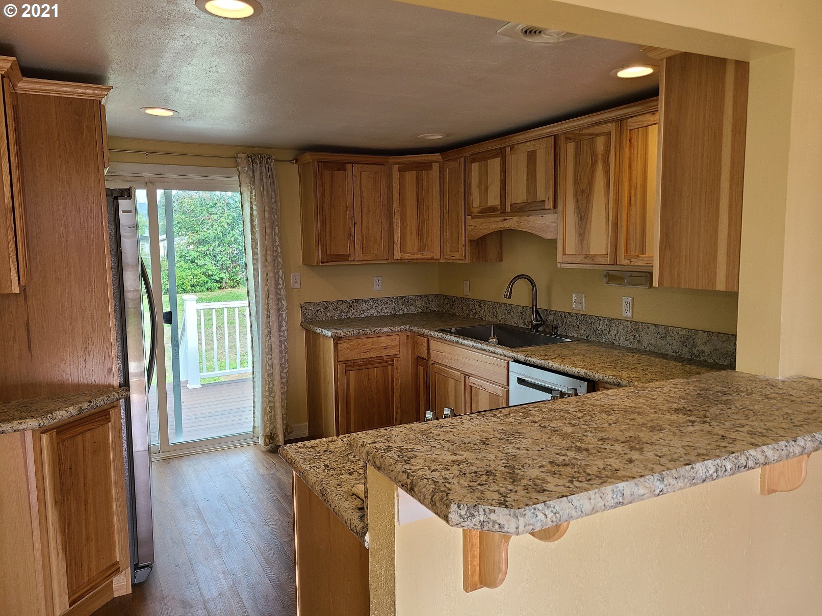 5158 D Street Springfield, OR 97478 - Photo 4 of 14 a kitchen with granite countertop a sink a counter top space and cabinets