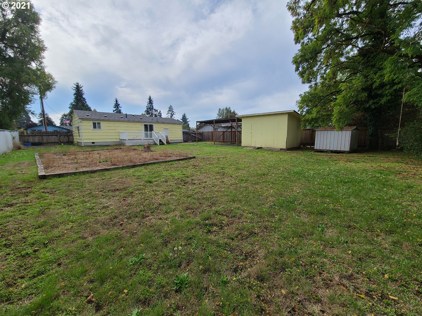 5158 D Street Springfield, OR 97478 - Photo 8 of 14 a view of a house with a big yard and a large tree