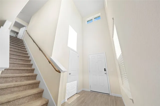 a view of staircase with white walls and white door