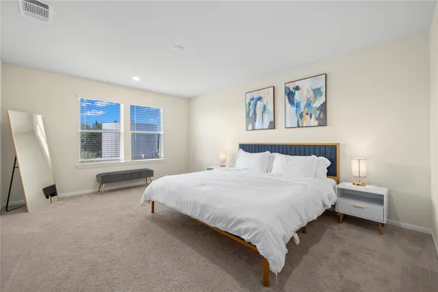 a spacious bedroom with a bed and a window