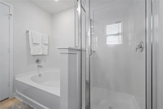 a white bath tub sitting next to a shower