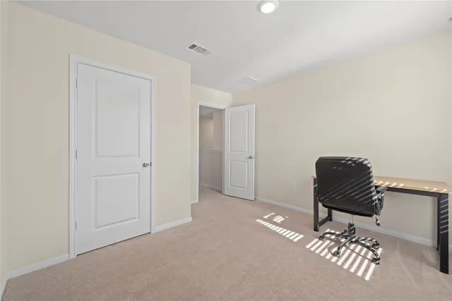 a view of a hallway with workspace and a couch