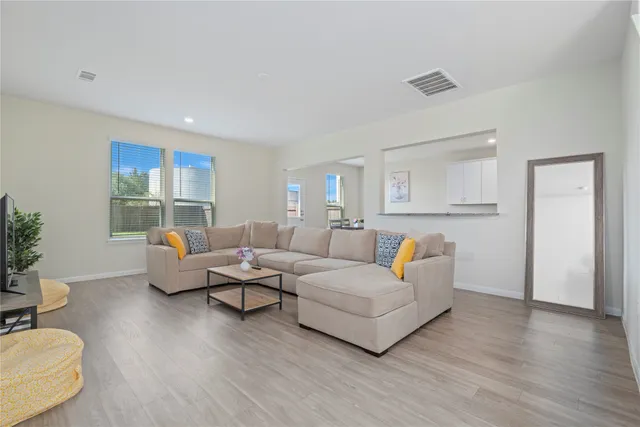 a living room with furniture and a wooden floor