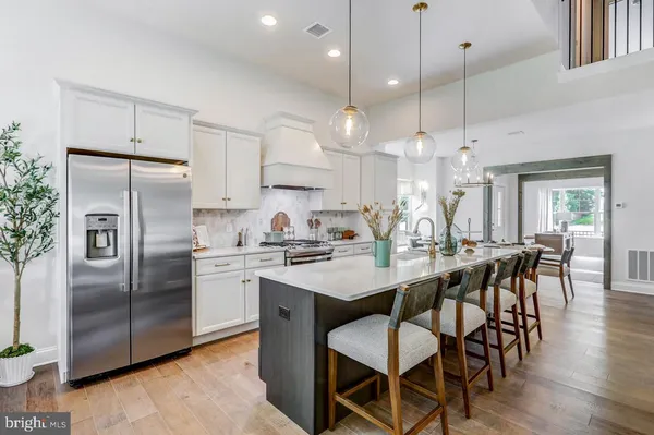 a kitchen with stainless steel appliances a dining table chairs stove refrigerator and microwave