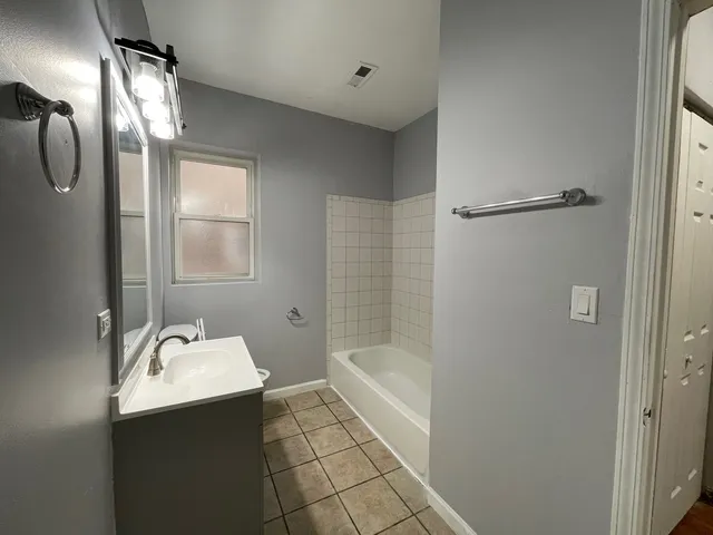 a bathroom with a sink mirror and shower