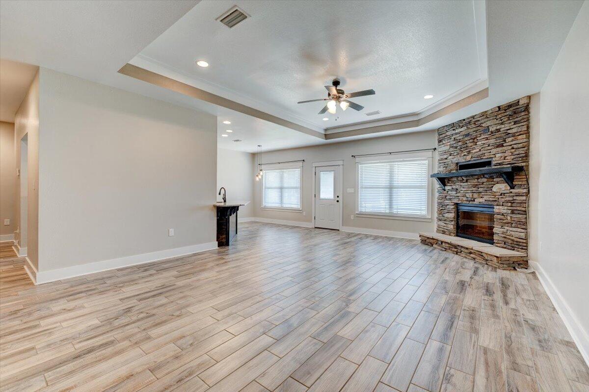 3956 Painter Branch Road Crestview, FL 32539 - Photo 4 of 28 an empty room with wooden floor fireplace and windows
