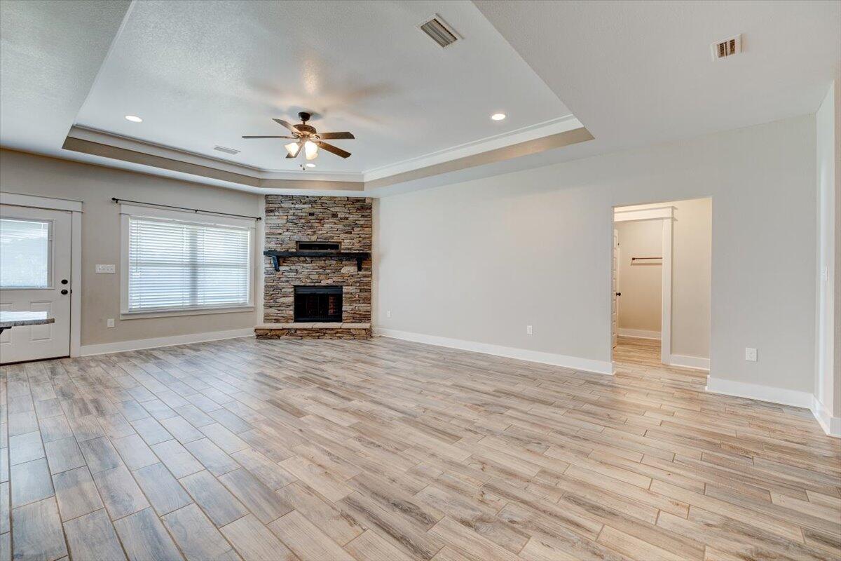 3956 Painter Branch Road Crestview, FL 32539 - Photo 5 of 28 an empty room with wooden floor fireplace and windows