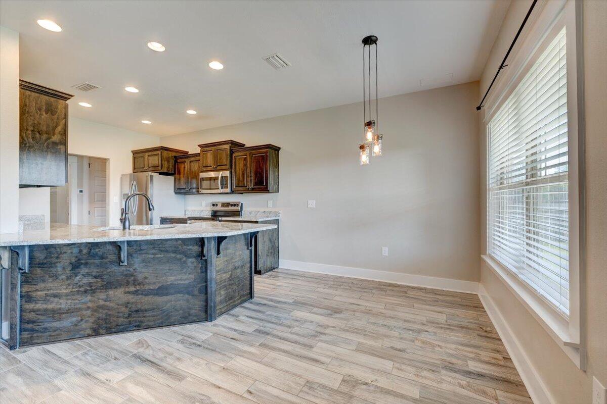 3956 Painter Branch Road Crestview, FL 32539 - Photo 7 of 28 a large kitchen with kitchen island a sink stainless steel appliances and cabinets